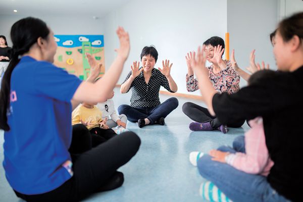 Parents and children participating in an activity at a Hangzhou early education school.